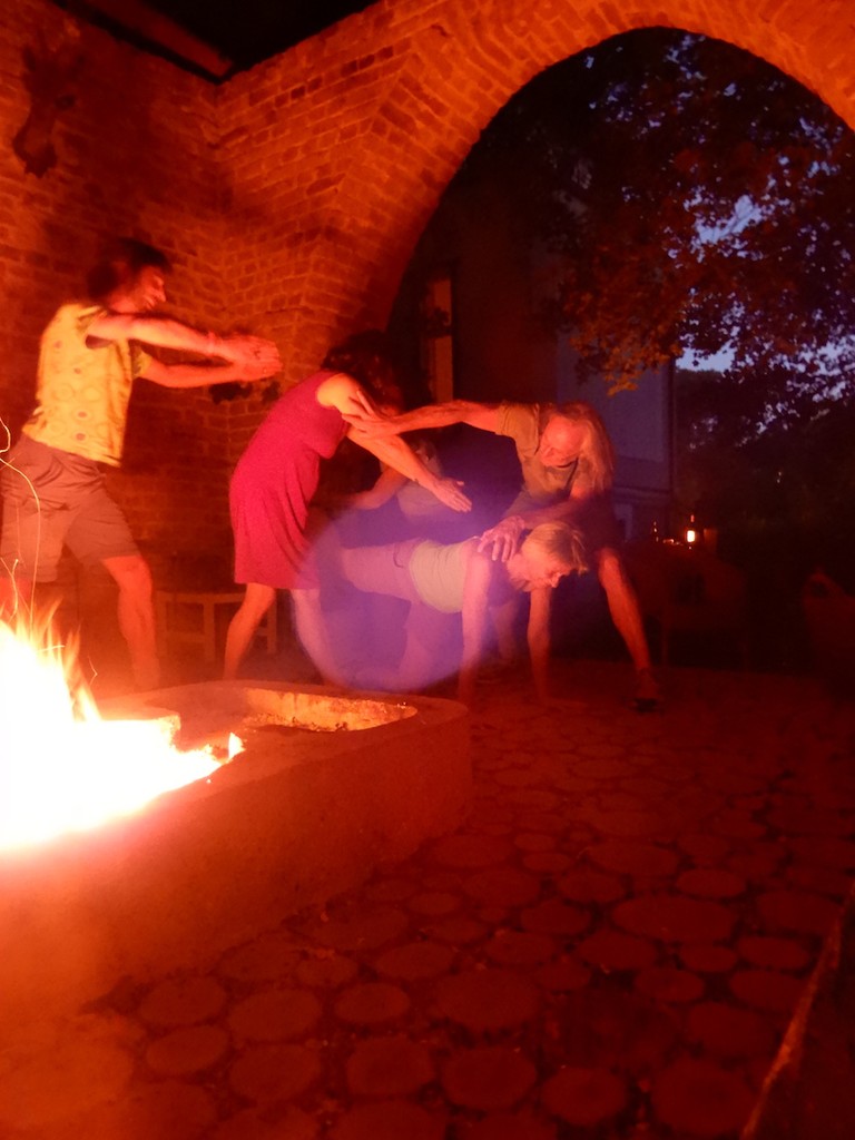 Zwei Frauen und Männer neben Lagerfeuer