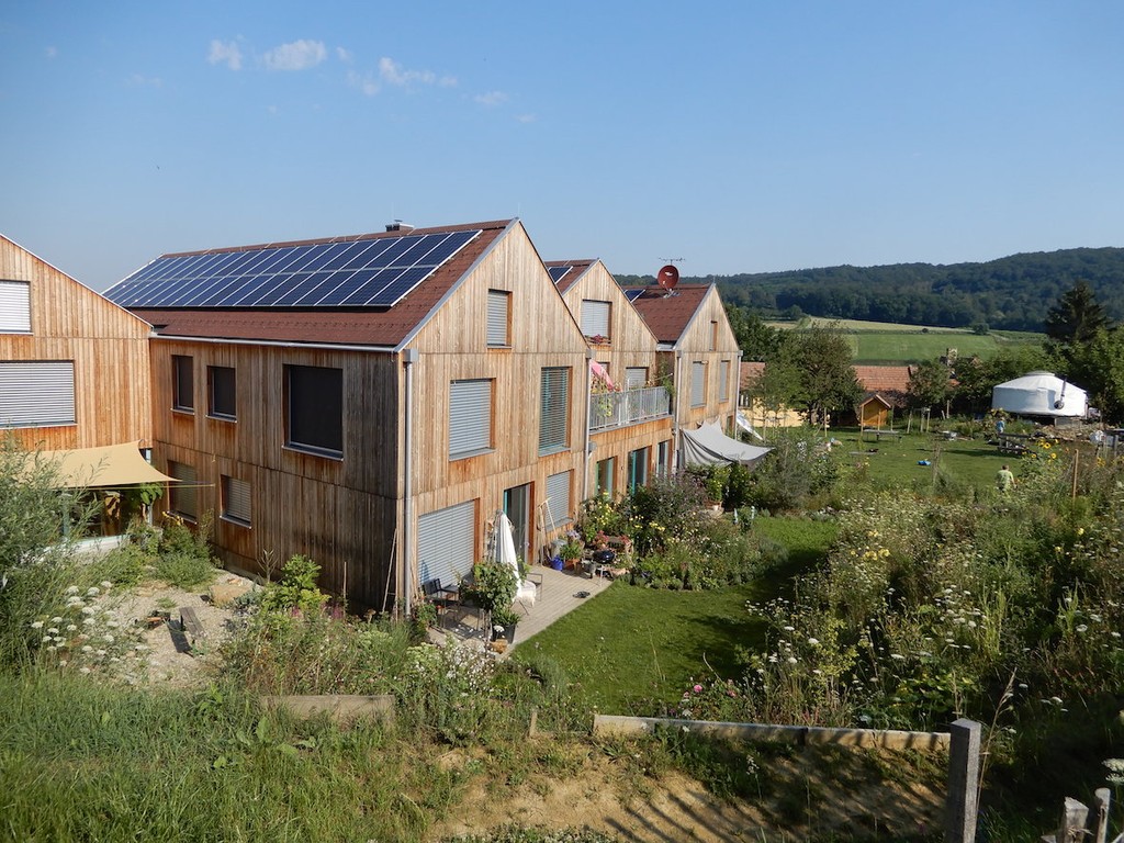 Blick aus den Gartenanlagen auf das Wohnprojekt Hasendorf bei Sonnenschein