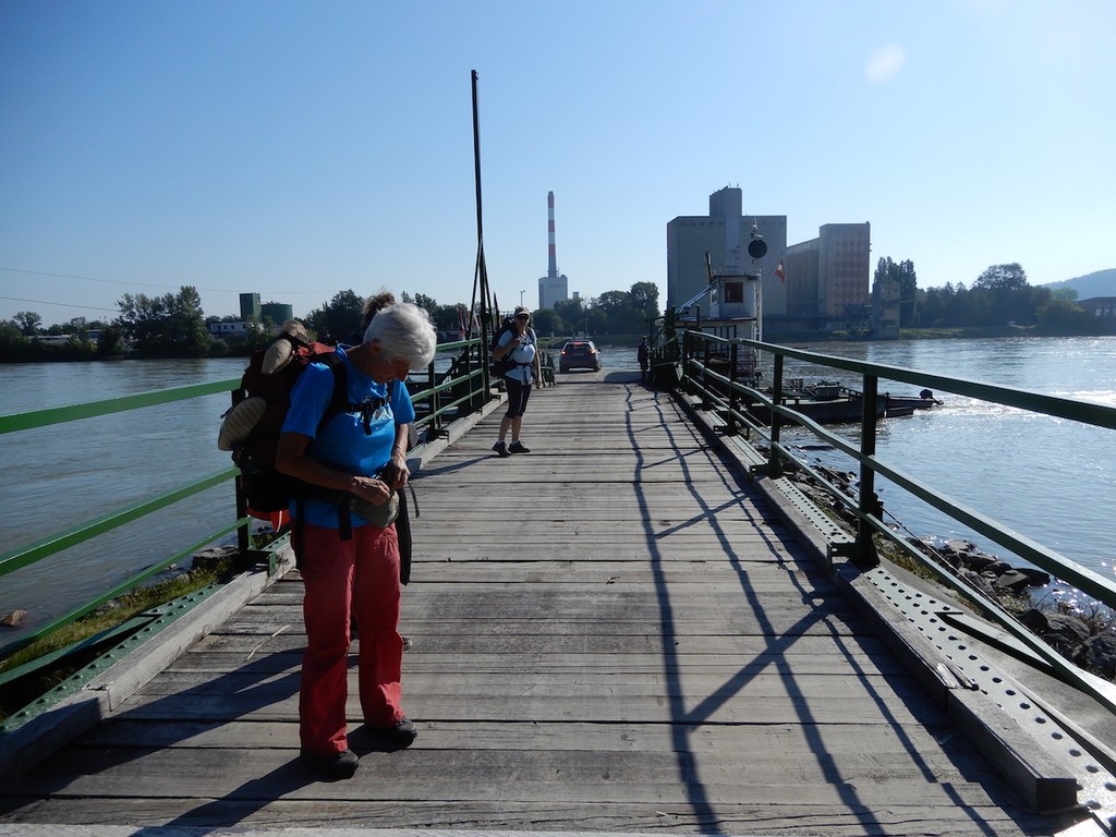 Frauen mit Rucksäcken auf Steg zur Fähre mit Blick auf Korneuburg